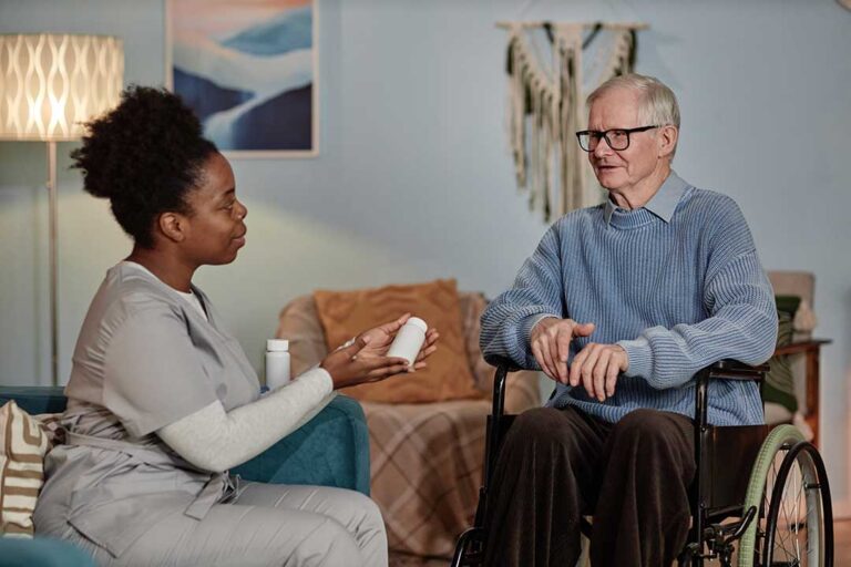 Older adult arranging family photos in a bright assisted living apartment with help from a relative.